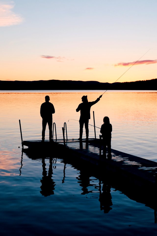 Three People On A Wooden Fishing Docks