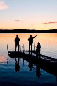 Three People On A Wooden Fishing Docks photo