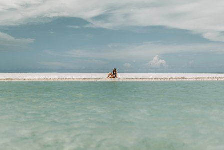 Person Sitting On White Sand photo