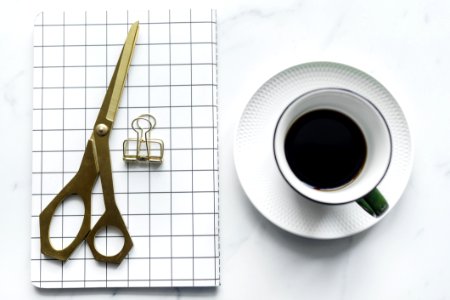 Cup Of Coffee Beside Book And Scissors photo