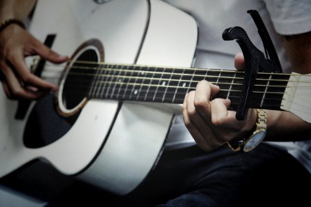 Man Holding A White Dreadnought Acoustic Guitar photo