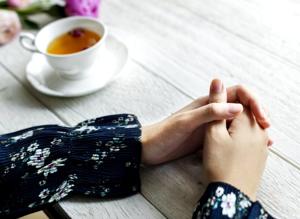 Person In Blue And White Sleeved Shirt Near On White Ceramic Teacup