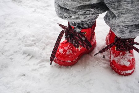 Toddler Wearing Red Shoes Standing On Snow photo