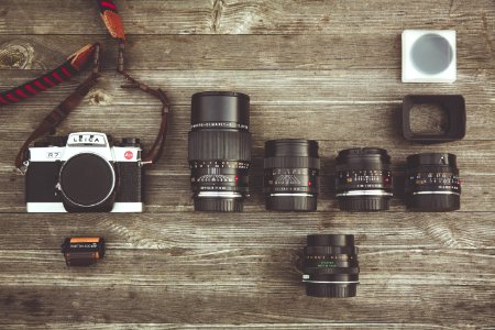 Black And Gray Dslr Camera With Assorted Lenses On Brown Wooden Surface