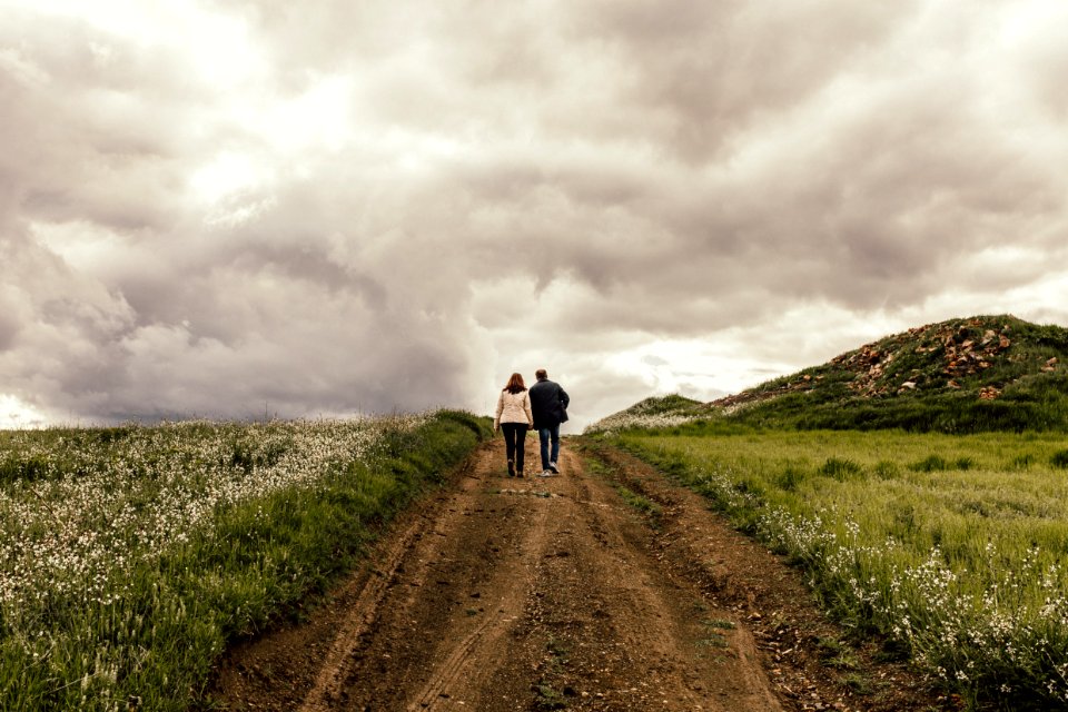 Man In Black Jacket Near Woman In White Jacket Surrounded By Flowers