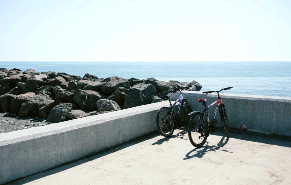 Two Bicycles Behind Gray Concrete Wall