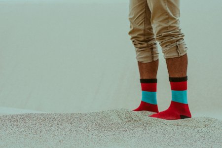 Person Wearing Red Socks Standing On Sand photo