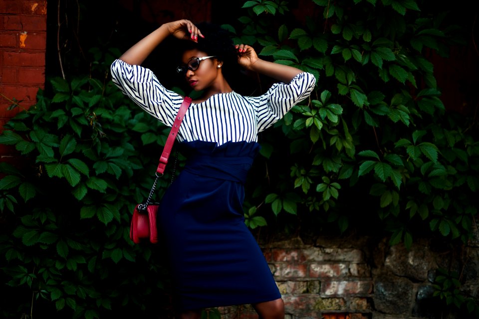 Woman In Black And White Striped Long-sleeved Dress Wearing Red Leather Sling Bag