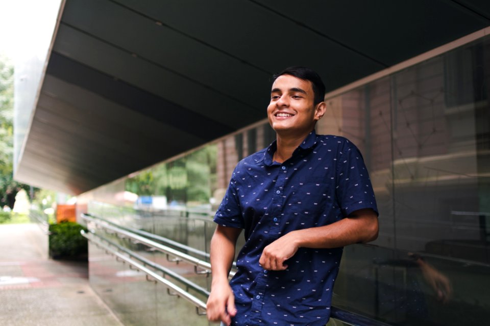 Man In Blue Button-up Shirt Standing Beside Glass Wall