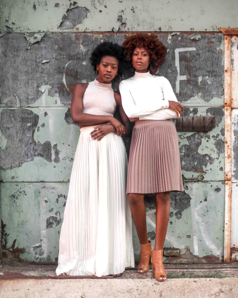 Two Women Standing Beside Wall At Daytime