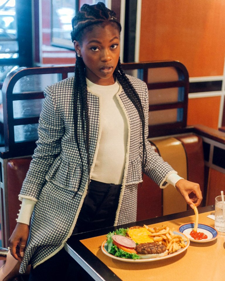 Woman In White And Black Jacket Standing Beside Table