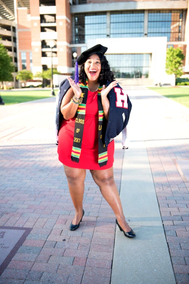 Woman Wearing Red Dress And Black Cap Taking Photo Near Building