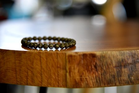 Beaded Gray Bracelet On Brown Wooden Table photo