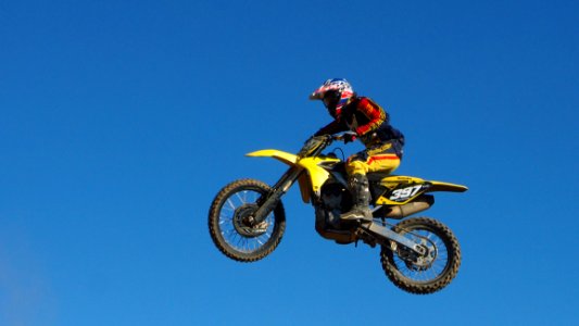 Man Riding Yellow Motocross Dirt Bike photo