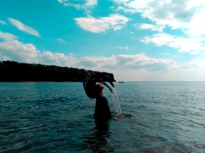 Woman In Black Shirt Lifting Her Hair From Water During Noontime