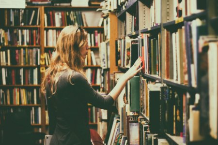 Woman In Black Long-sleeved Looking For Books In Library photo