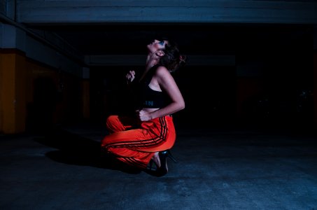 Woman In Black Crop Top Sitting On Concrete Floor photo