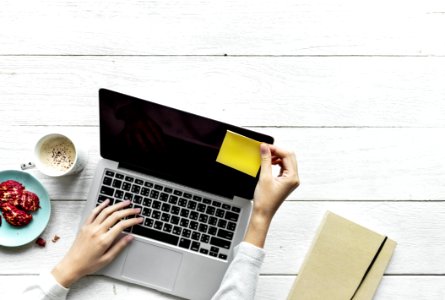 Person Holding Black And Grey Laptop Computer On Top Of White Wood Surface photo