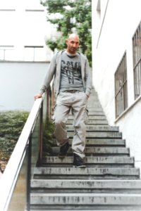 Man Wearing Gray Jacket Standing On Stair