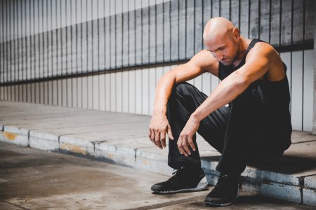 Man Sitting On Sidewalk photo