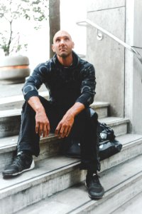 Man Sitting On Concrete Stair Looking Up photo