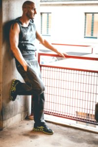 Man In Black Tank Top Leaning On Wall photo