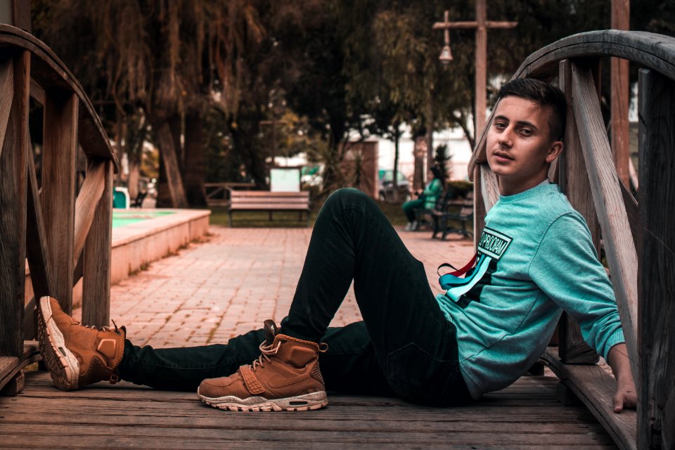 Man Sits On Wooden Bridge