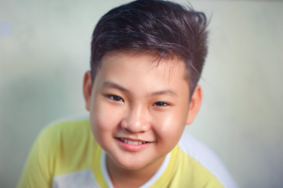 Close-up Photography Of Boy Wearing White And Yellow Shirt photo