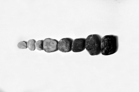 Row Of Black And Gray Polished Pebble On Gray Surface