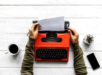 Person Operating Red Typewriter photo