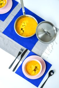 Gray Metal Cooking Pot With Cook Food Beside Bowl And Cutlery Set On Top Of Table photo