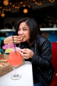 Woman Wearing Black Leather Jacket Eating Pizza photo