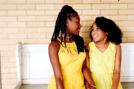 Two Girls Wearing Yellow Sleeveless Dresses photo