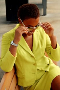 Woman Holding Sunglasses Sitting On Bench photo