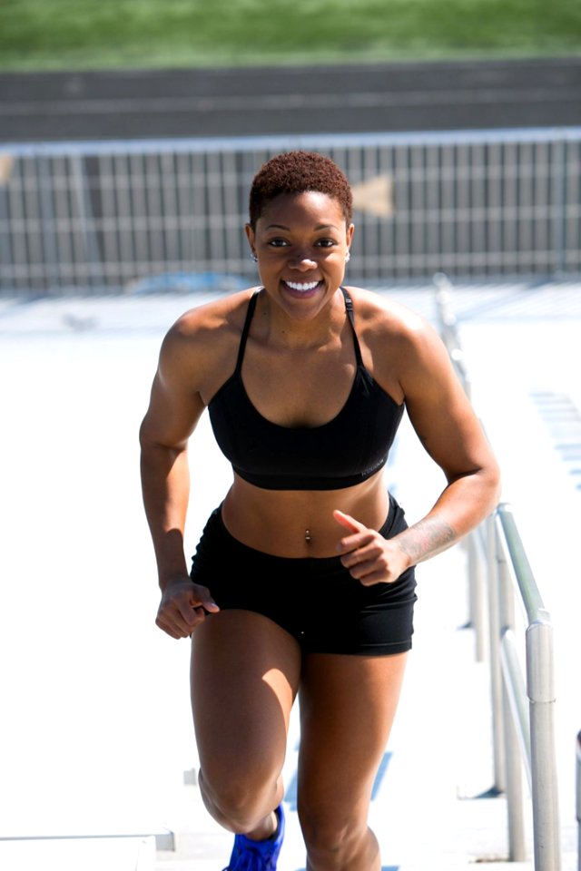 Woman Wearing Black Sports Bra And Jogger Shorts Smiling