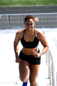 Woman Wearing Black Sports Bra And Jogger Shorts Smiling photo