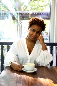 Woman Wearing White Deep V-neck Long-sleeved Blouse Holding White Ceramic Teacup