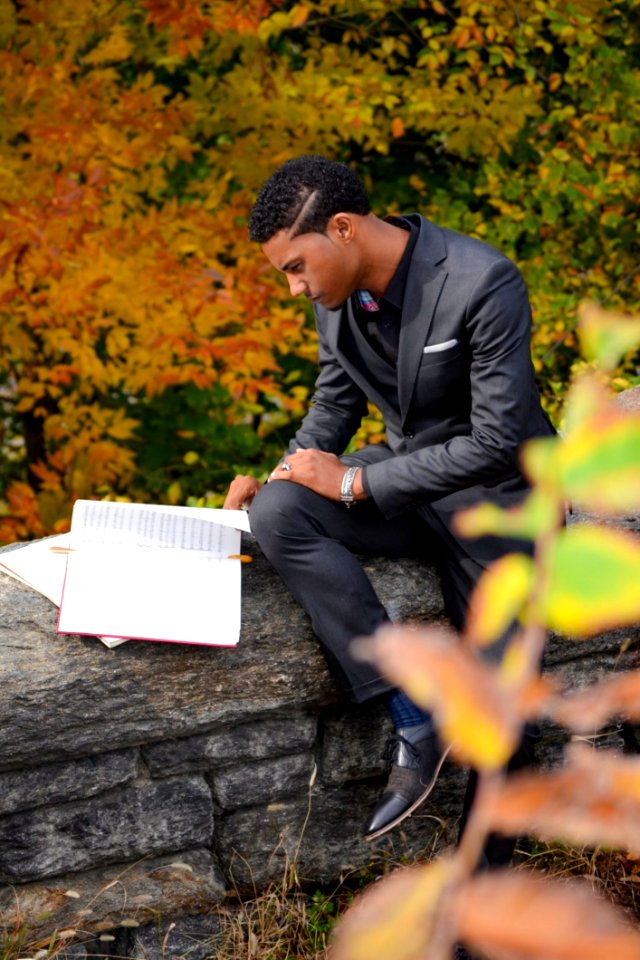 Man Wearing Black Suit Reading Book