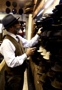 Man Picking Hats In Rack photo