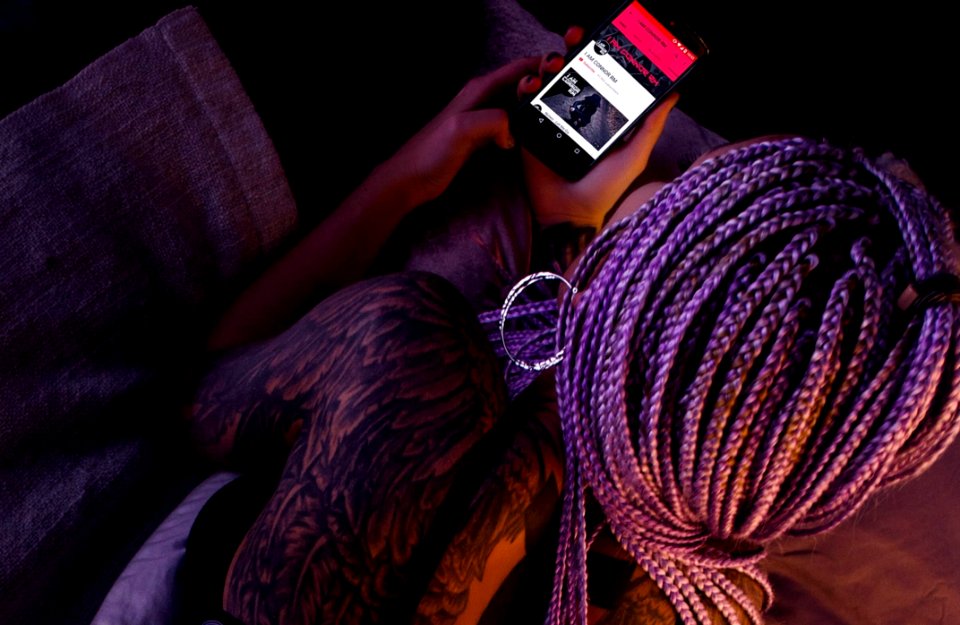 Woman With Purple Braided Hair Holding An Android Smartphone