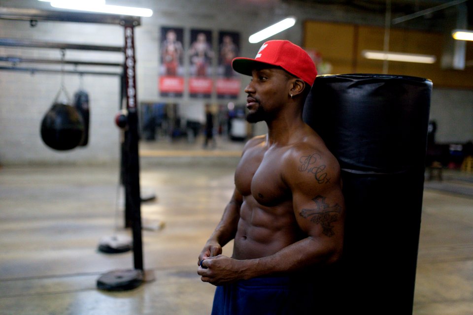 Man Leaning On Black Punching Bag