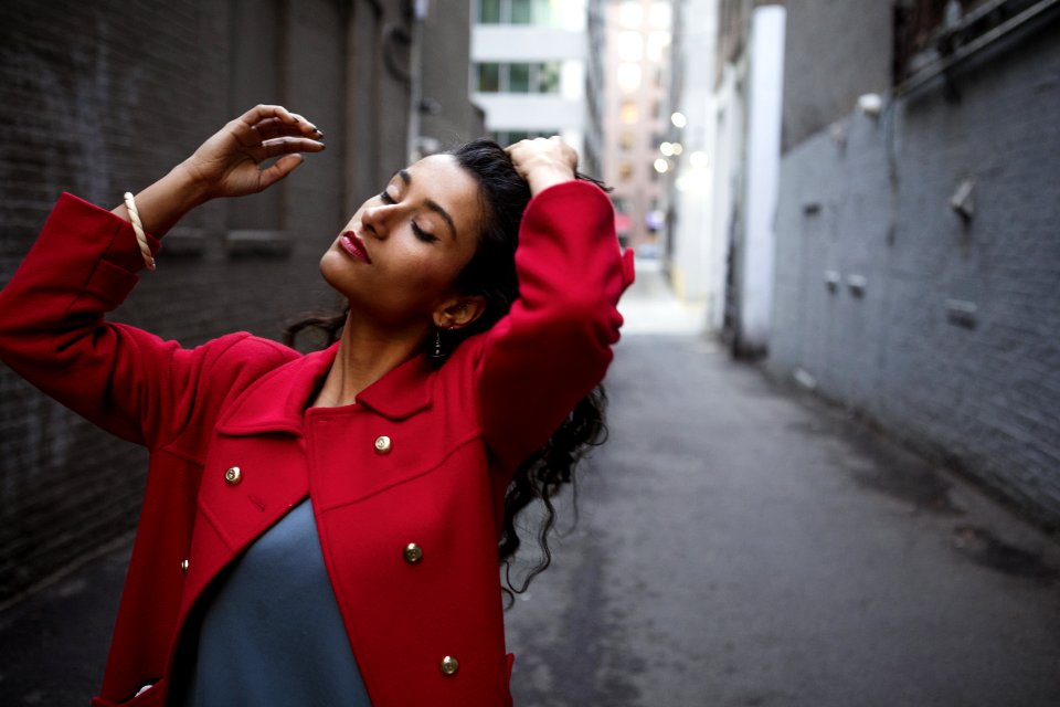 Woman In Red Coat Between Gray Concrete Walls