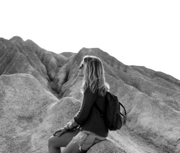 Grayscale Photo Of Woman Sitting On Rock photo