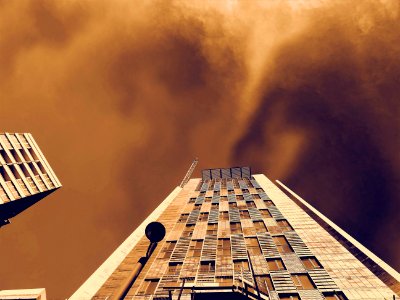 Low-angle Photography Of Brown Concrete Building Under Brown Clouds photo