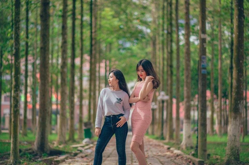 Woman In Pencil Dress Beside Woman In Gray Sweatshirt And Blue Jeans Standing On Pathway