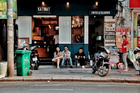 Three People Sitting On Chairs Outside Coffee amp Tea House Near Motorcycles photo