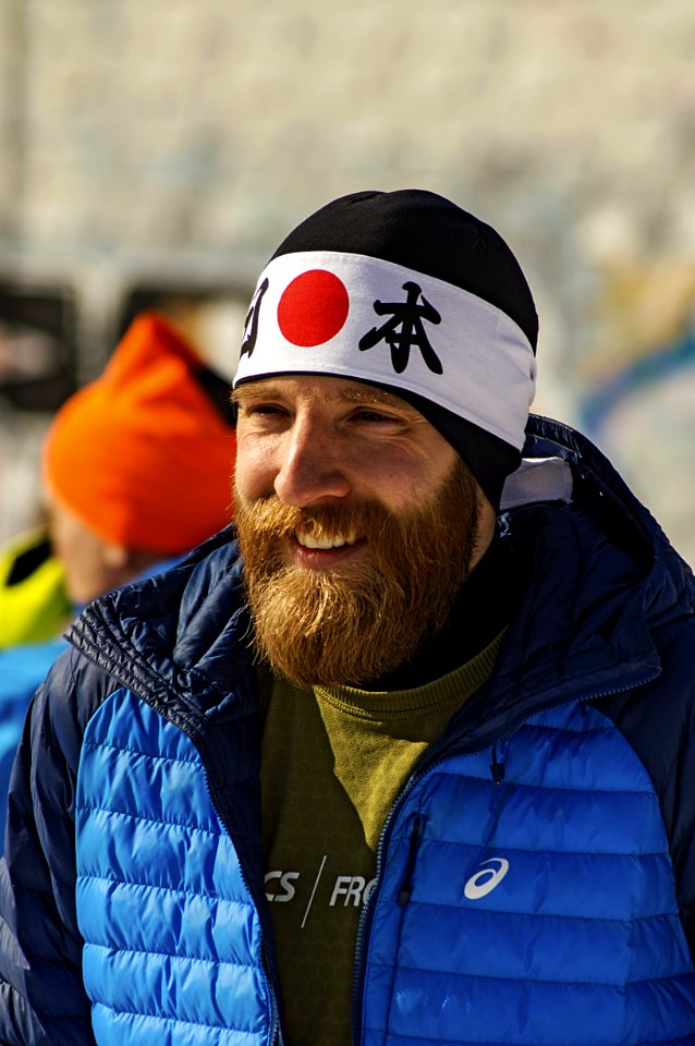 Smiling Man In Blue And Black Zip-up Bubble Jacket