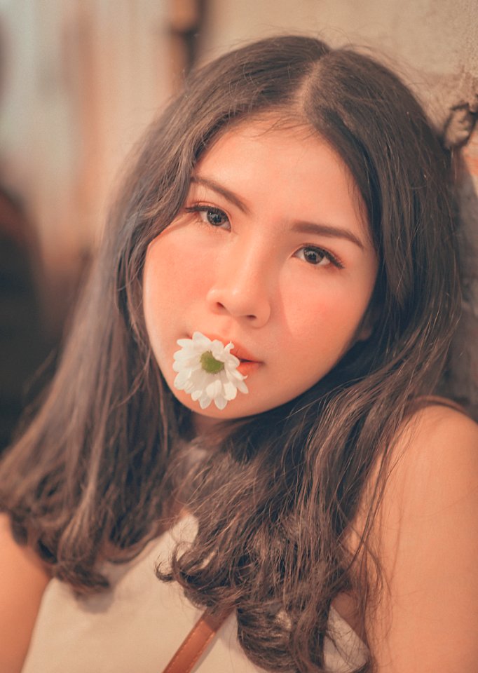 Woman Having A White Daisy On Her Mouth