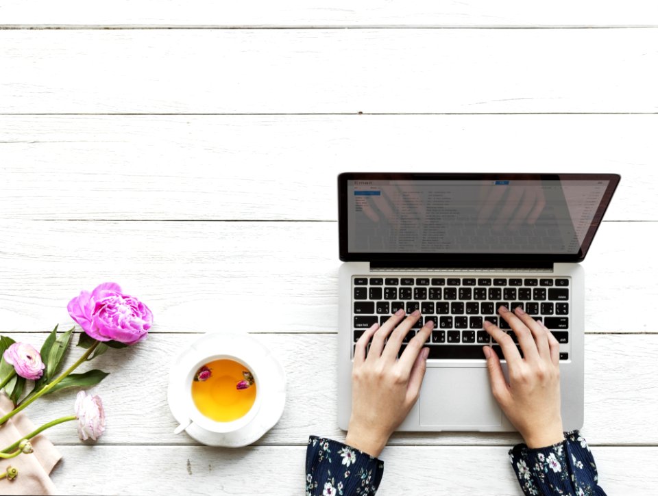 Macbook Pro Beside White Cup And Saucer On Table
