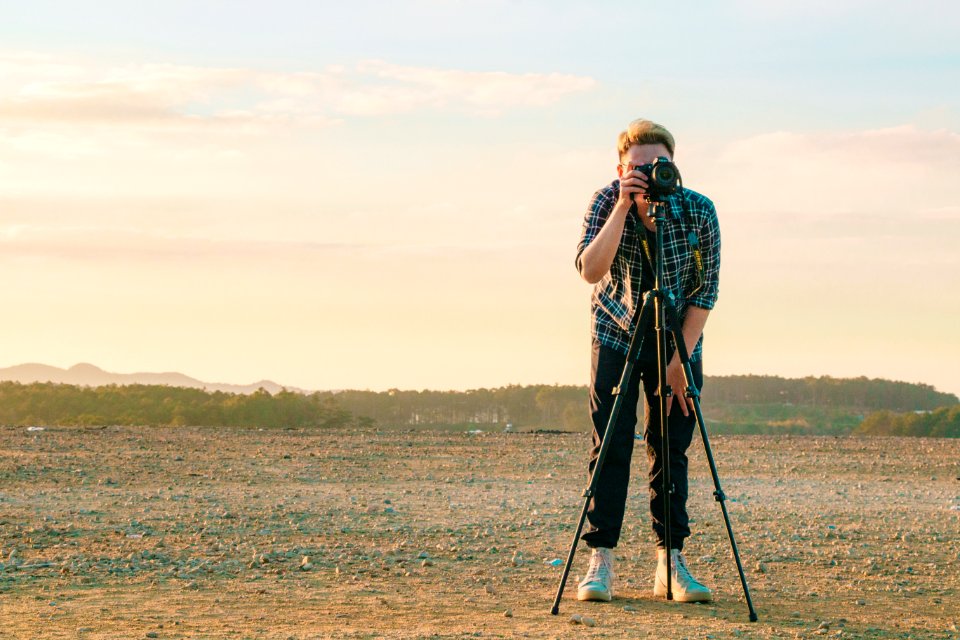Man Wearing Sport Shirt While Holding Camera